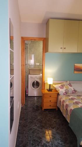 a bedroom with a bed and a washing machine at Estudios Dalia in Vecindario