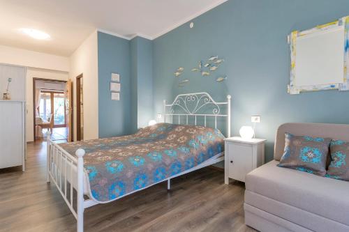 um quarto azul com uma cama e um sofá em Apartment Rio em Fasana