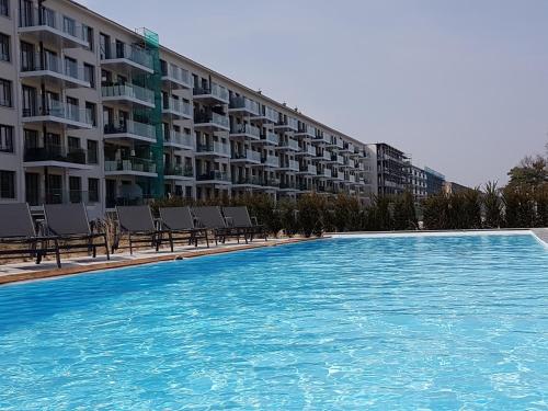 a large swimming pool with chairs in front of a building at Prora Solitaire Apartment mit Meerblick Block 2 in Binz