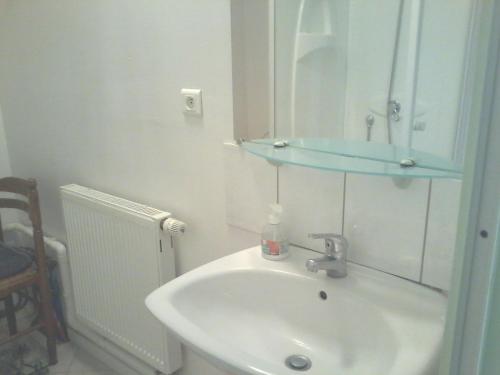 a white bathroom with a sink and a mirror at Le Trèfle d'Or in Gérardmer