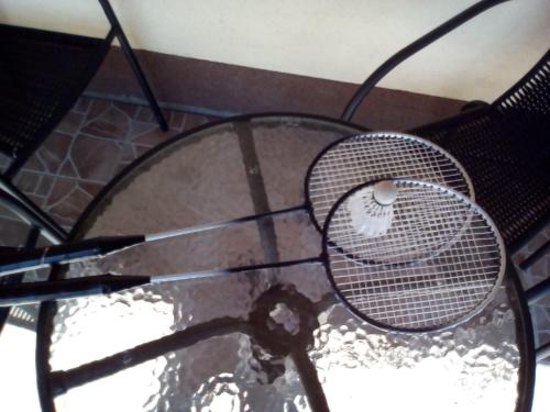 a tennis racket sitting on top of a glass table at Potyka Apartman in Tiszafüred