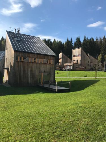 an old barn in a field of green grass at Chalet6harrachov se saunou in Harrachov