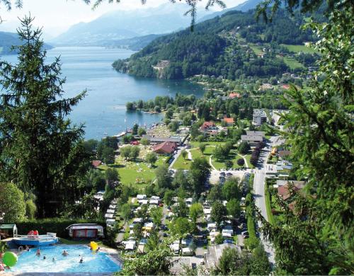 a group of people swimming in a large pool in a lake at Schwimmbad Camping Mössler in Döbriach