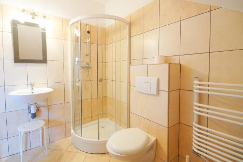 a bathroom with a shower and a toilet and a sink at Koral in Władysławowo