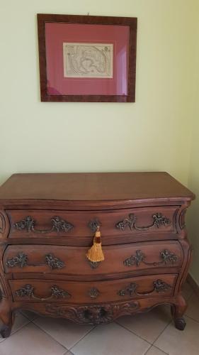 a wooden dresser with a picture on the wall at Casa vacanze Cristina in Imperia