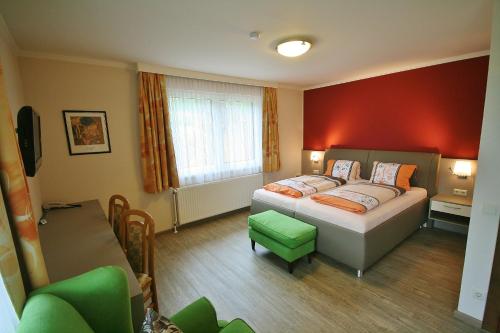 a bedroom with a bed with a red wall at Pension Stöcklmühl in Oberdrauburg