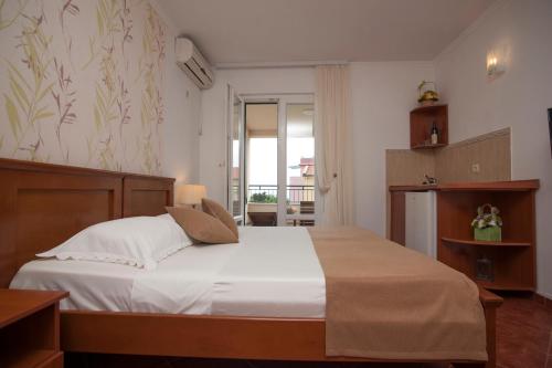 a bedroom with a large bed with white sheets at Guest House Medin in Petrovac na Moru
