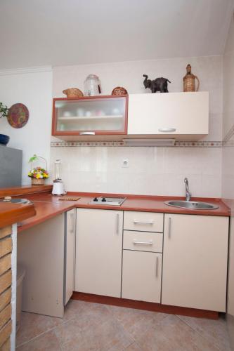 a kitchen with white cabinets and a sink at Guest House Medin in Petrovac na Moru
