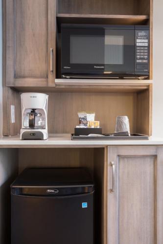 a kitchen with a black microwave and a coffee maker at Hotel La Vista Azul in Turtle Cove