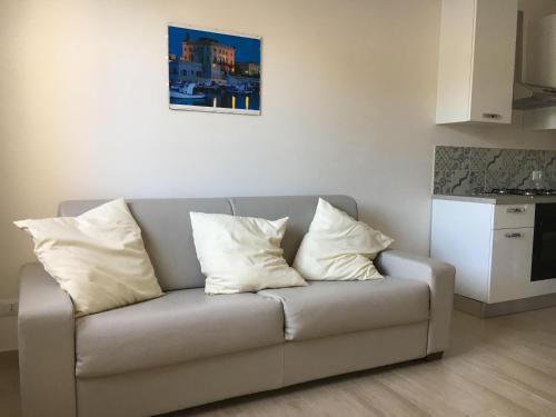 a couch with three pillows sitting in a living room at Favignana Holidays in Favignana