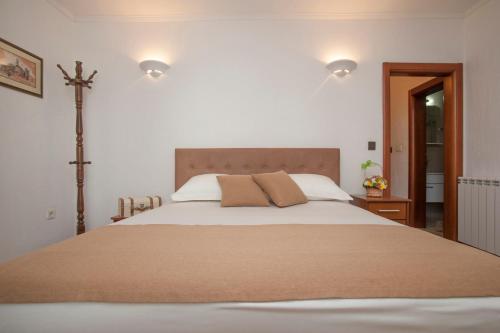 a bedroom with a large bed with a cross on the wall at Guest House Medin in Petrovac na Moru