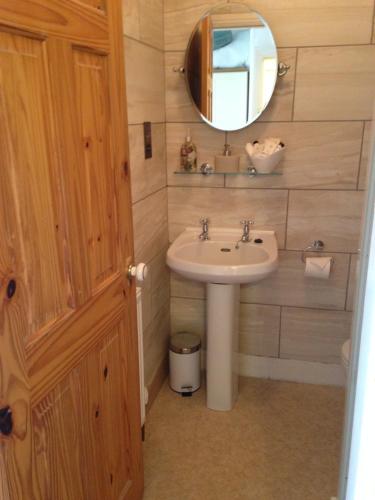 een badkamer met een wastafel en een spiegel bij School House Cottage B&B and tea garden in Hawkshead