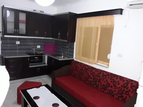 a small kitchen with a red couch in a room at Olive Tree Apartment in Sarandë