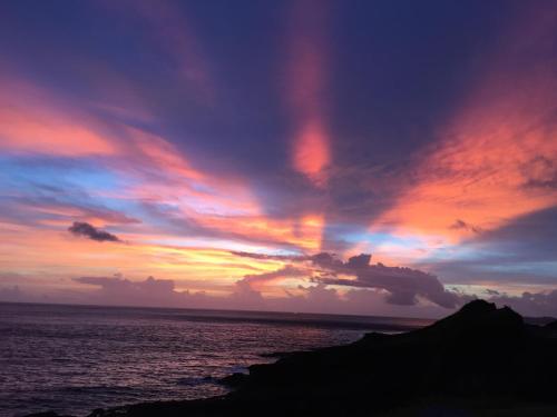 a sunset over the ocean with a cloudy sky at A-HOME in Jiufen