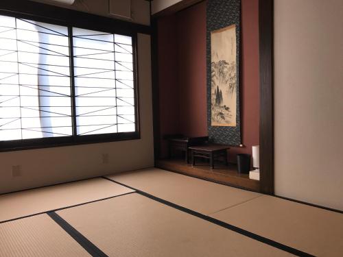 an empty room with a window and a table at Guest House Kuranomachi ゲストハウス蔵の街 in Tochigi