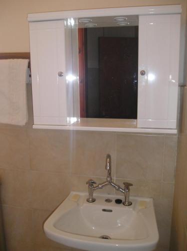 a bathroom with a sink and a mirror at Tina Hotel in Chania Town
