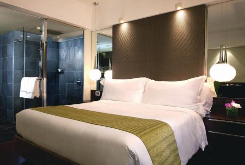 a bedroom with a large bed with white pillows at The Mira Hong Kong in Hong Kong