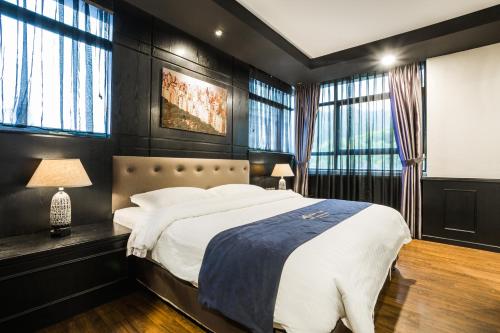 a bedroom with a large bed and windows at Manhattan Business Hotel Damansara Perdana in Petaling Jaya