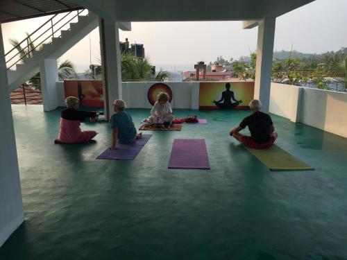 a group of people sitting on the floor doing yoga at The Ocean Park Beach Resort in Kovalam