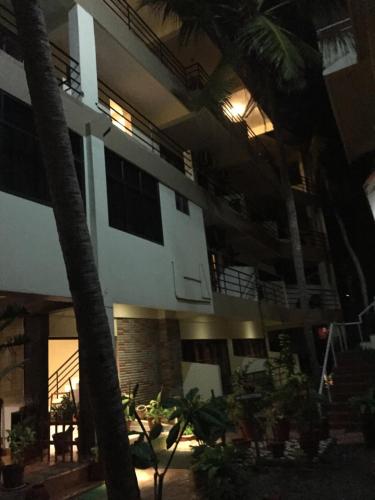 a building with palm trees in front of it at The Ocean Park Beach Resort in Kovalam