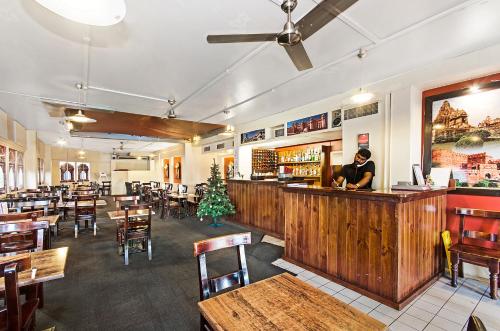 a restaurant with tables, chairs, and tables in it at Adventurers Backpackers in Townsville