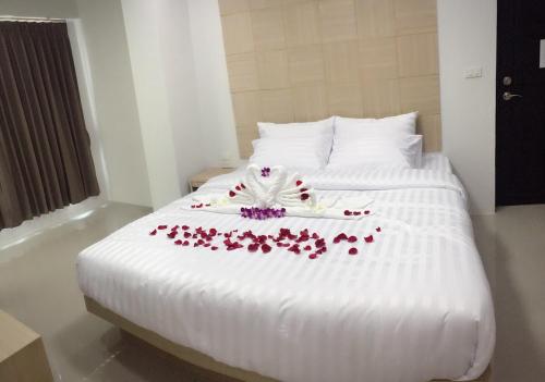 a white bed with flowers on it in a room at Nava Grand in Ban Talat Rangsit