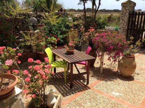a table and chairs in a garden with flowers at Favignana Vacanze in Favignana
