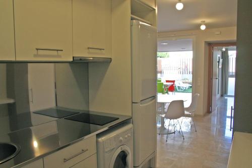 a kitchen with a refrigerator and a dishwasher at L' Escala Resort in L'Escala