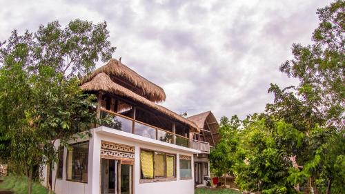a house with a thatch roof on top of it at Vertical House Bali in Uluwatu