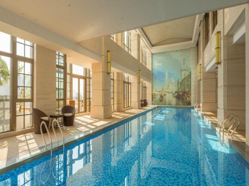 深圳的住宿－深圳南山G公寓，一座带壁画的建筑中的大型游泳池