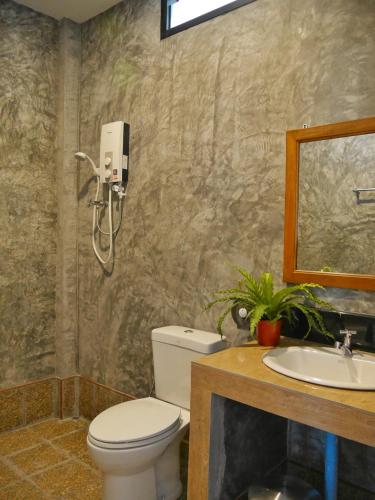 a bathroom with a toilet and a sink and a mirror at Koh Tao Heritage in Ko Tao