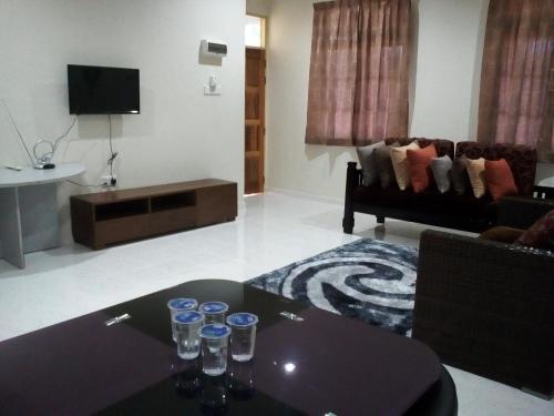 a living room with a table and a couch at Teratak Tok Wan 1 and 2 in Kota Bharu