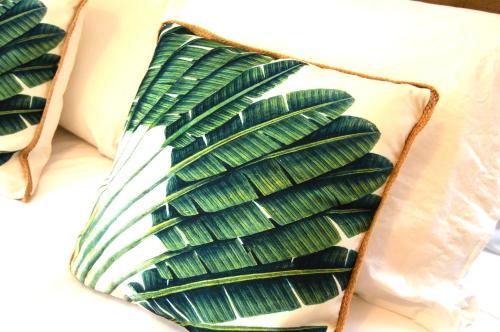 een groene handdoek met groene veren op een bed bij La Casa del Reloj Cadiz in Cádiz