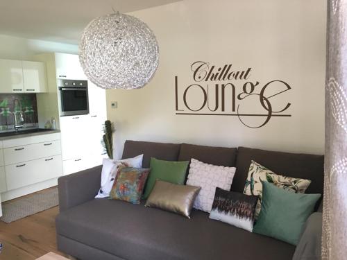 a living room with a gray couch with pillows at Ferienwohnung Sailer in Bruck an der Mur