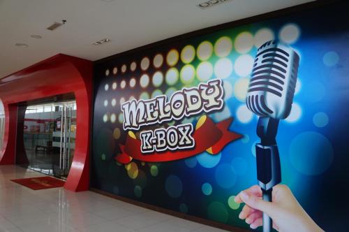 a person holding a microphone in front of a wall at Greens Hotel & Suites in Bintulu