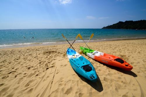 two kayaks are sitting on the sand on the beach at The Briza Beach Resort, Khao Lak SHA Extra Plus in Khao Lak