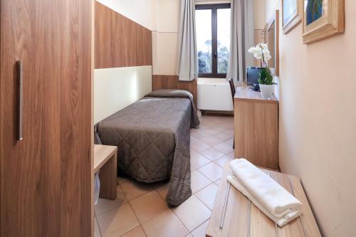 a small room with a bed and a television at Hotel Arno Bellariva in Florence