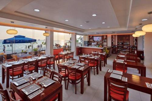 a restaurant with wooden tables and chairs and the ocean at Shore Time Hotel Boracay in Boracay