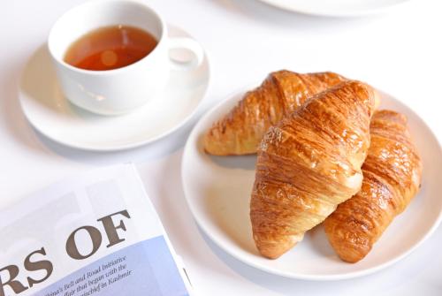 a plate with two croissants and a cup of tea at Futian Shangri-La, Shenzhen,Near to Shenzhen Convention&Exhibition Centre, Futian Railway Station in Shenzhen