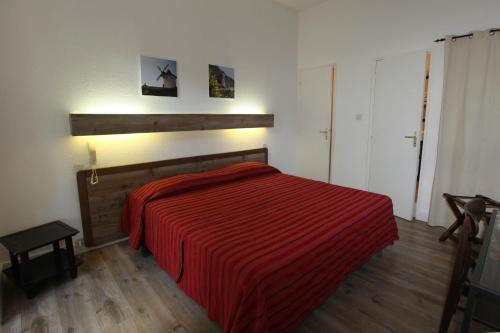 a bedroom with a bed with a red striped blanket at Hôtel U Pozzu in Sisco