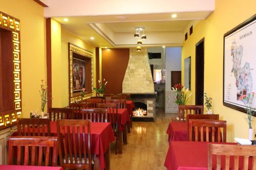 a restaurant with red tables and chairs and a fireplace at Sapa Local House in Sapa