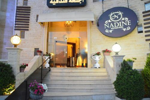 a building with stairs in front of a restaurant at Nadine Hotel Suites in Amman