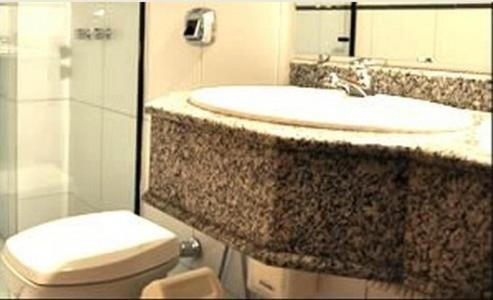 een badkamer met een wastafel en een toilet bij Hotel Ceolatto Palace - Aeroporto in Várzea Grande