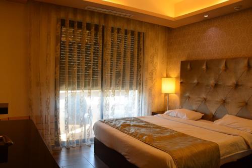 a bedroom with a large bed and a window at Nadine Hotel Suites in Amman