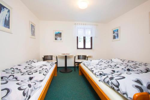 a room with two beds and a table in it at Chata Pod lipami in Rokytnice nad Jizerou