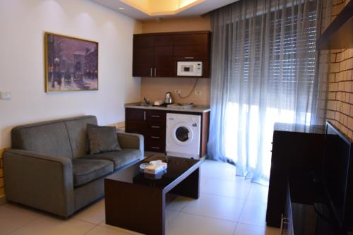 a living room with a couch and a microwave at Nadine Hotel Suites in Amman