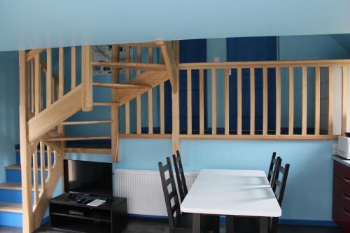 a room with a table and a spiral staircase at La Grange Du Festel in Oneux