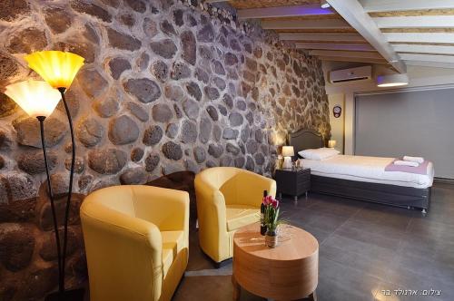 um quarto de hotel com uma cama e duas cadeiras e uma mesa em בקתה מקום טוב באמצע em Kinneret
