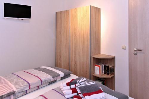 a bedroom with two beds and a tv on the wall at Extrablatt in Oberhof