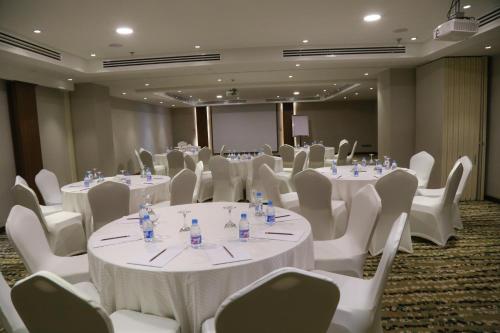 a conference room with white tables and chairs at Sumou Hotel Al Khobar in Al Khobar